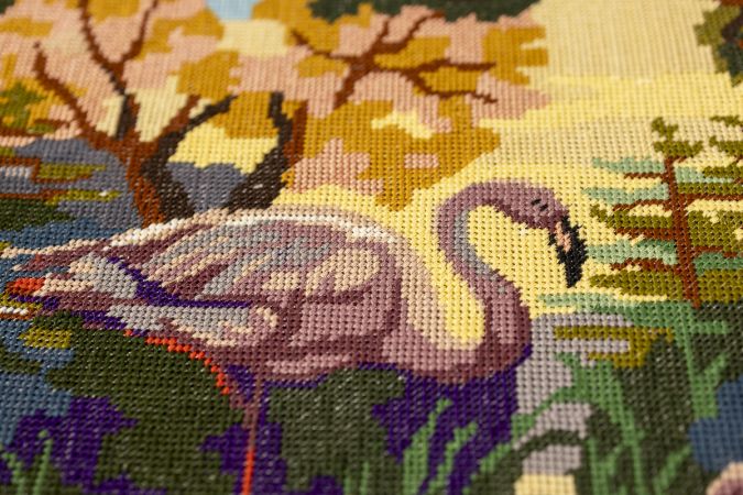 Textile wall panel showing restored embroidery framed with hand-cut faux leather elements